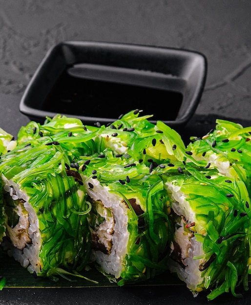 Conjunto de sushi uramaki decorado com wasabi e salada de algas