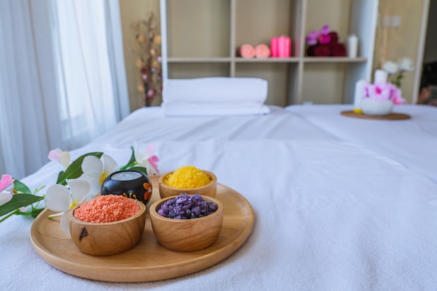 Conjunto de tratamento de spa e óleo de massagem aromática na massagem da cama. Cenário tailandês para aromaterapia e massagem com flores na cama, relaxar e cuidados saudáveis.