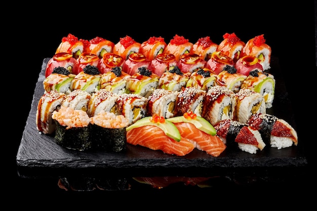 Conjunto de uramaki nigiri sushi e gunkan maki com atum e enguia salmão em fundo preto