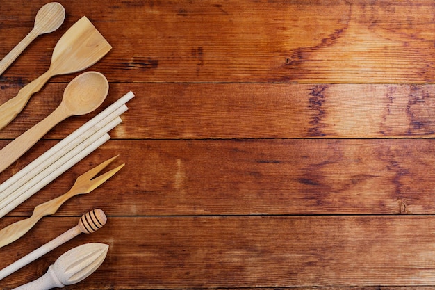Foto conjunto de utensílios de cozinha de madeira na mesa de madeira. talheres de madeira em pranchas velhas. talheres ecológicos. conceito de desperdício zero. copie o espaço. vista do topo