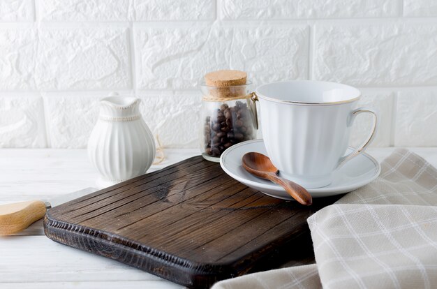 Conjunto de utensílios para café, um copo, um leiteiro e uma lata de grãos de café