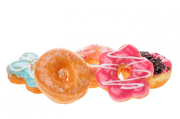 Conjunto de deliciosas donas de colores aislados sobre superficie blanca.