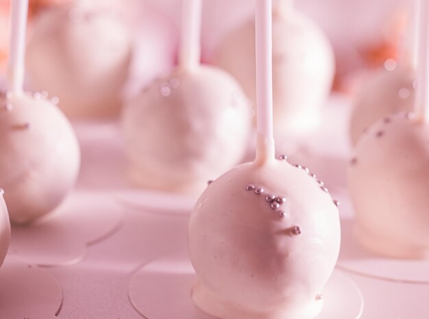 El conjunto de deliciosos cake pops cubiertos con crema rosa Los pasteles esféricos con un primer plano de palo