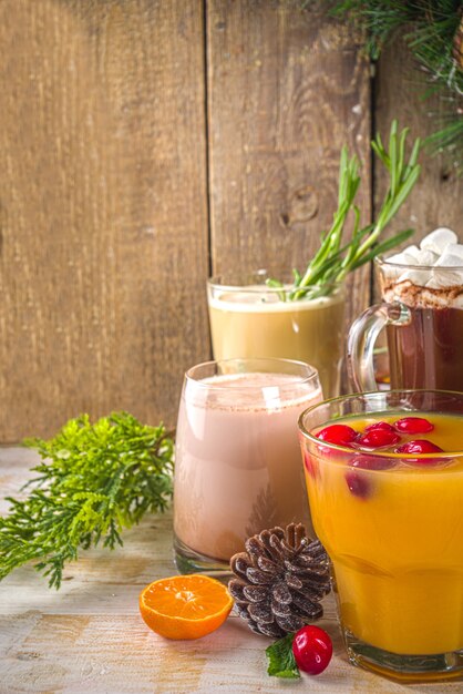 Conjunto de diferentes bebidas navideñas en una acogedora casa de madera con decoración navideña