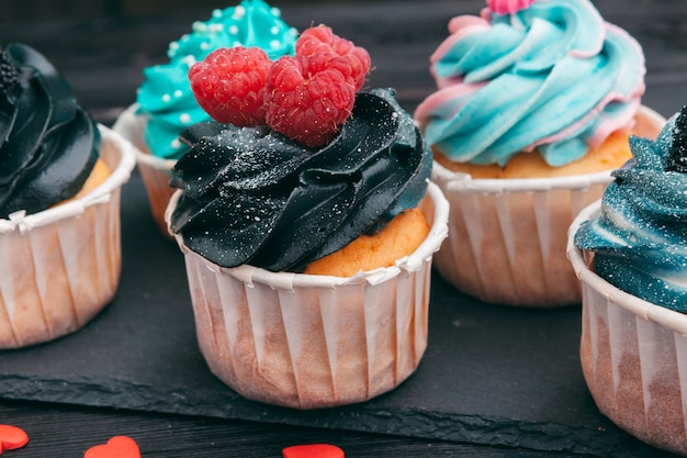 Conjunto de diferentes deliciosos cupcakes en la oscuridad