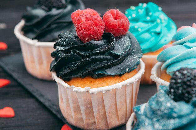 Conjunto de diferentes deliciosos cupcakes en la oscuridad