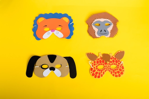 Conjunto de diferentes máscaras artesanales de vinilo sobre un fondo amarillo