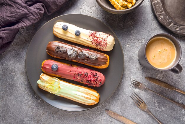 Conjunto de diferentes pasteles de eclair sobre fondos oscuros