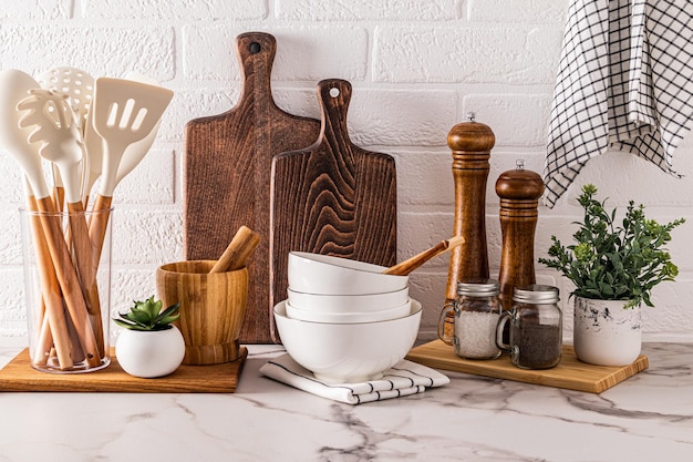 Un conjunto de diferentes platos y herramientas ecológicas en una moderna encimera de mármol de cocina Vista frontal de fondo de cocina fácil de usar