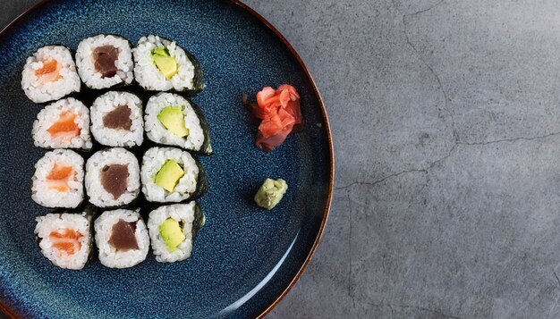 Conjunto de diferentes tipos de rollos de sushi con atún salmón y aguacate Sobre fondo rústico con espacio para texto