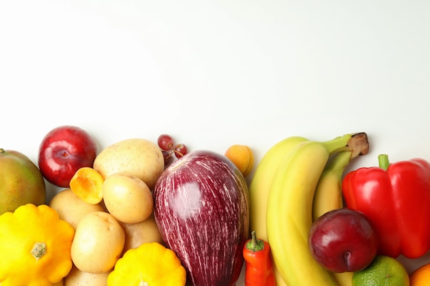 Conjunto de diferentes verduras y frutas sobre fondo blanco.