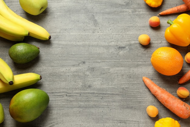 Conjunto de diferentes verduras y frutas sobre fondo de textura gris