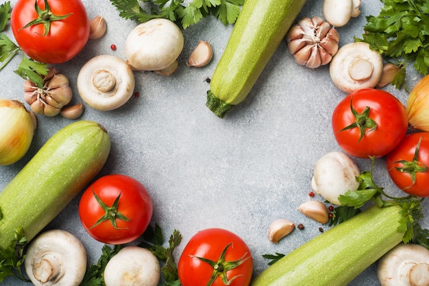 Conjunto de diferentes verduras de temporada sobre un fondo de hormigón gris.