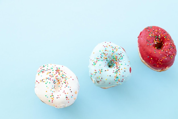 Conjunto de donas de colores aisladas sobre fondo azul Vista superior estilo realista