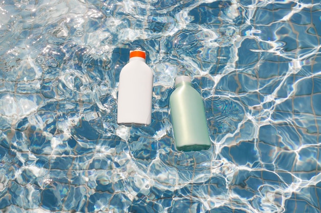 Conjunto de dos tubos de crema de botella de protección solar de cosméticos en blanco en el concepto de cuidado de la piel del cuerpo de la piscina