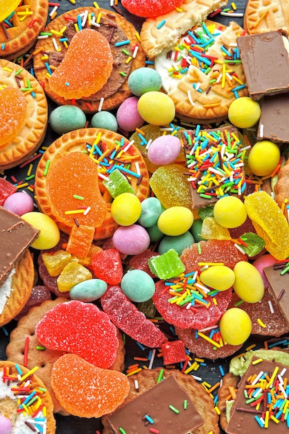 Foto un conjunto de dulces y caramelos de colores. celebración con dulces. comida chatarra.