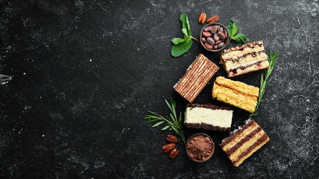 Conjunto de dulces trozos de pasteles y dulces sobre un fondo de piedra negra Vista superior