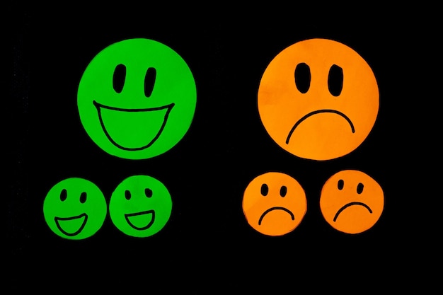 Conjunto de emoticonos de sonrisa y tristeza aislados sobre fondo negro Iconos de línea emoticonos Emoticonos felices e infelices Conjunto de emoji Color verde y naranja