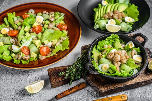 Conjunto de ensaladas con aguacate, gambas, camarones y verduras en cuencos