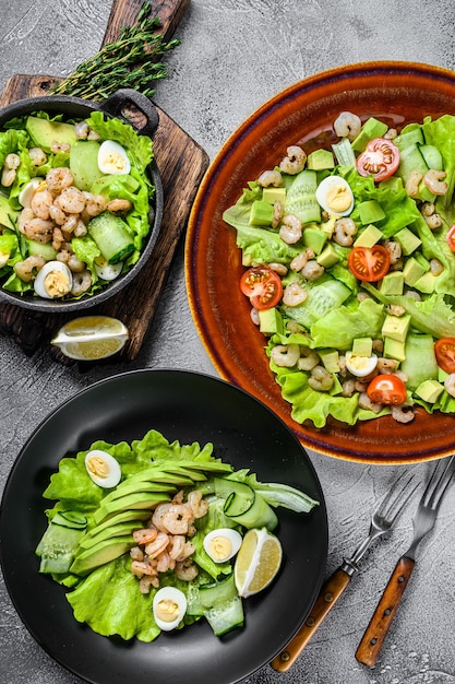 Conjunto de ensaladas con aguacate, langostinos, camarones y verduras en cuencos.