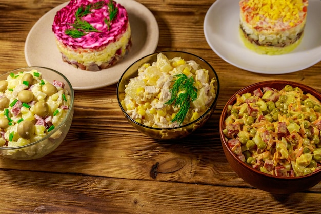 Conjunto de ensaladas festivas de mayonesa en mesa de madera