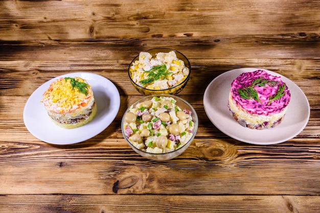 Conjunto de ensaladas festivas de mayonesa en mesa de madera