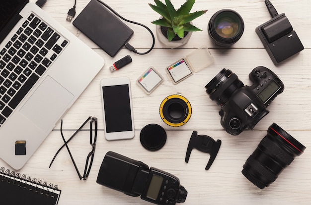 Conjunto de equipo fotográfico moderno en mesa de madera blanca, vista superior. Herramientas profesionales de diseñador creativo, fondo de trabajo de fotógrafo