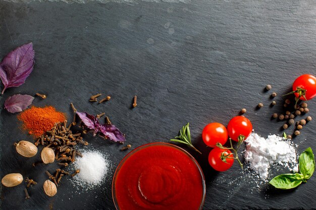 un conjunto de especias en una piedra oscura para cocinar ingredientes de ketchup espacio para el concepto de comida de texto