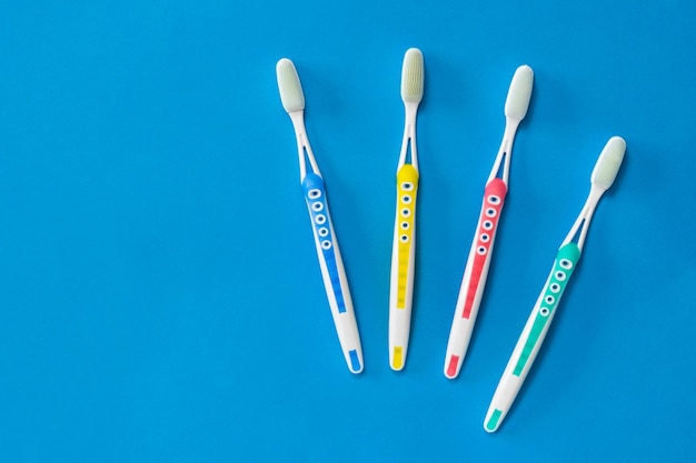 Conjunto familiar de escovas de dentes com cerdas de silicone em um fundo azul. Conceito de higiene bucal na família. Meios para cuidar da cavidade oral.