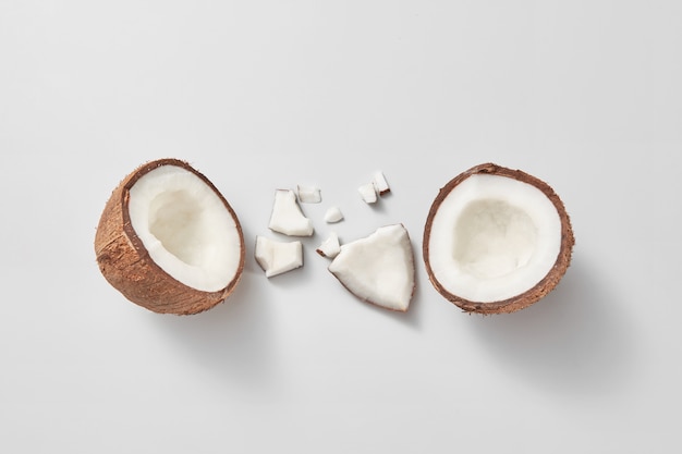 Conjunto de fruta de coco exótica orgánica natural madura recién cortada sobre un fondo gris claro con sombras suaves y espacio de copia. Concepto vegano. Vista superior.