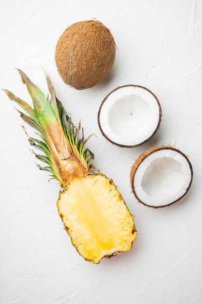 Conjunto de frutas frescas, piña y coco, sobre fondo de mesa de piedra blanca, vista superior plana