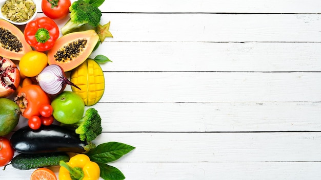 Conjunto de frutas y verduras sobre fondo blanco de madera Fondo de alimentos Vista superior Espacio libre para su texto