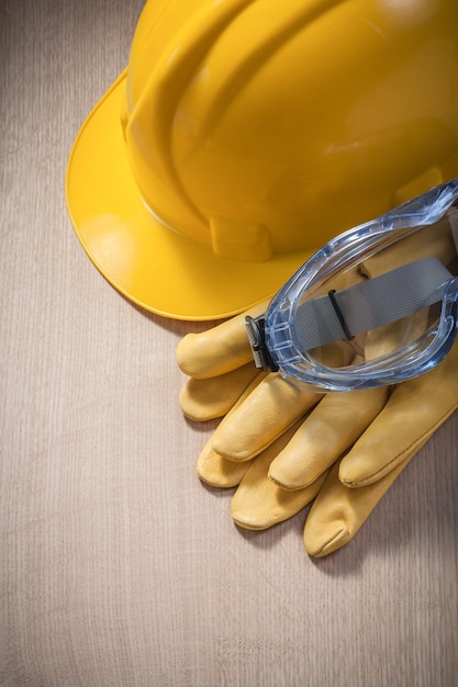 Conjunto de gafas de guantes protectores de casco en el concepto de construcción de tablero de madera