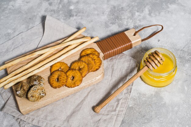 Conjunto de galletas en la tabla de cortar de madera, miel.