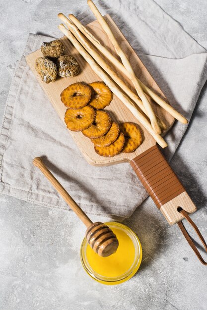 Conjunto de galletas en la tabla de cortar de madera, miel.