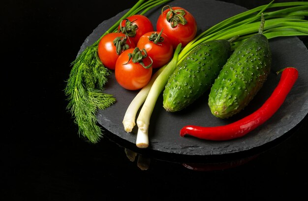 Conjunto grande para ensalada de verduras frescas Tomates rojos y cebollas verdes jóvenes con pepino en un plato