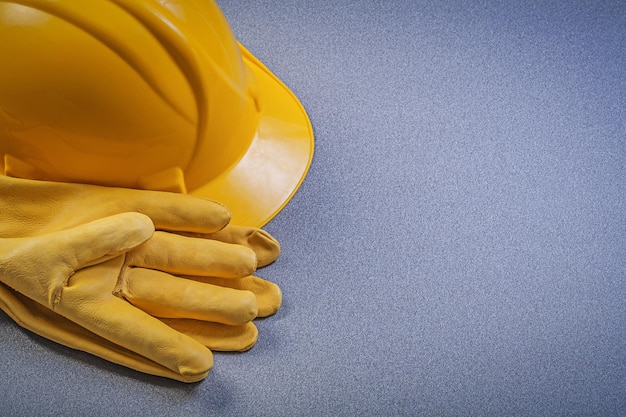 Conjunto de guantes protectores construyendo casco en concepto de construcción de fondo gris