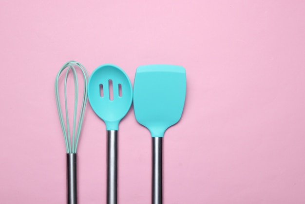 Conjunto de herramientas para cocinar en rosa. Paletas de silicona con asas de metal y batidor. Vista superior. Copia espacio