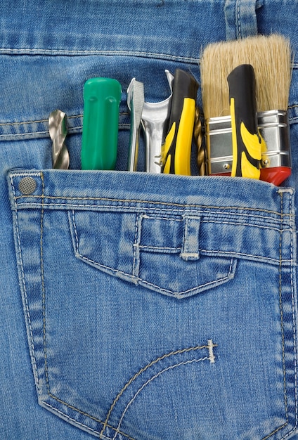 Conjunto de herramientas e instrumentos en el bolsillo de los pantalones vaqueros