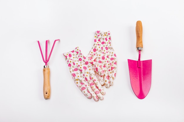 Conjunto de herramientas femeninas trabajando jardín flores rosadas