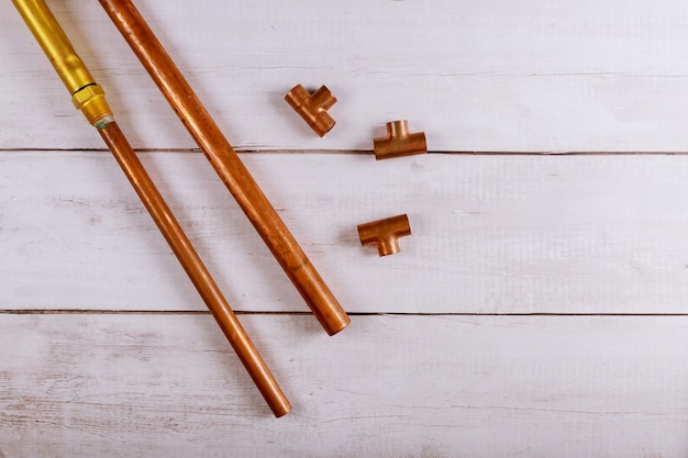 Conjunto de herramientas de mejora de la casa de fontanería de tuberías de cobre sobre tabla de madera