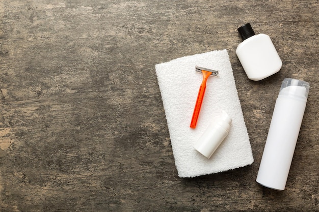 Conjunto de hombre de afeitado loción de toalla de máquina de afeitar y espuma de afeitar sobre fondo de color Accesorios de baño para hombres vista superior