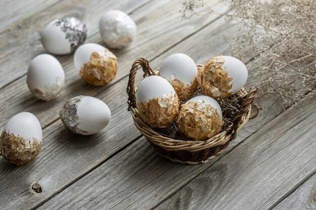 Conjunto de huevos de Pascua festivos en una canasta de mimbre sobre una mesa borrosa. Concepto de vacaciones de semana Santa.