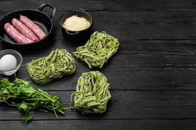 Conjunto de ingredientes alimentarios de la cocina italiana, sobre fondo de mesa de madera negra, con espacio para copiar texto