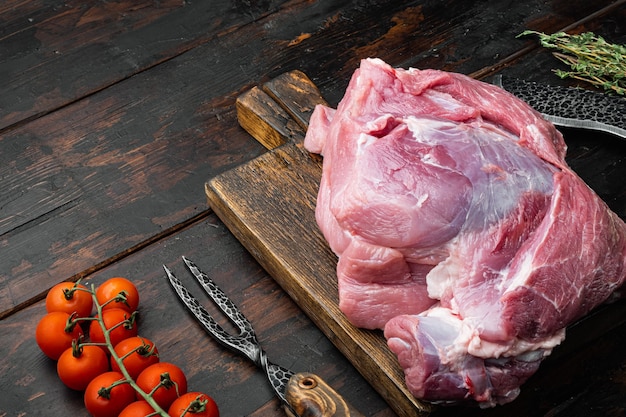 Conjunto de ingredientes de carne de cerdo, sobre fondo antiguo de mesa de madera oscura, con espacio para copiar texto