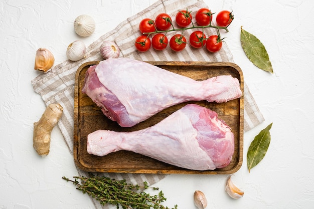 Conjunto de ingredientes de patas de pavo crudo, sobre fondo de mesa de piedra blanca, vista superior plana