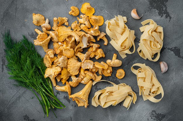 Conjunto de ingredientes de setas de rebozuelos de pasta, sobre fondo de mesa de piedra gris, vista superior plana