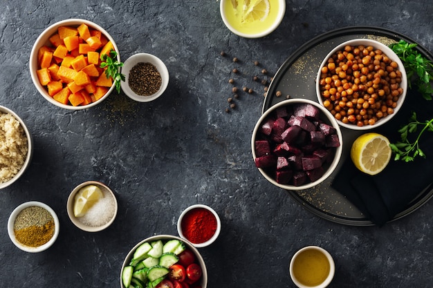 Conjunto de ingredientes vegetarianos saludables para cocinar. Garbanzos con especias, calabaza al horno y remolacha, quinua y verduras.