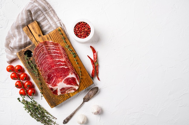 Conjunto de jamón de cuello de cerdo Coppa, sobre fondo de mesa de piedra blanca, vista superior plana, con espacio para copiar texto