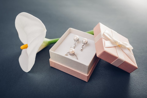 Conjunto de joyas de perlas en la caja de regalo con flores de lirio